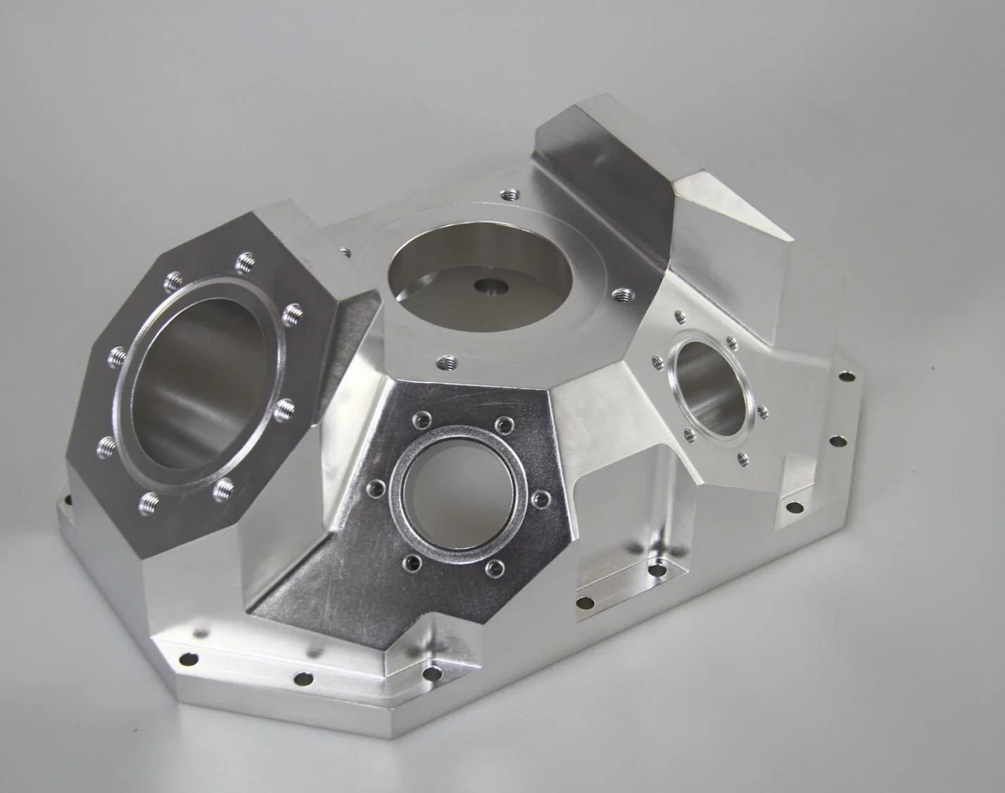 Multi-interface housing with bores and features on differently oriented faces
